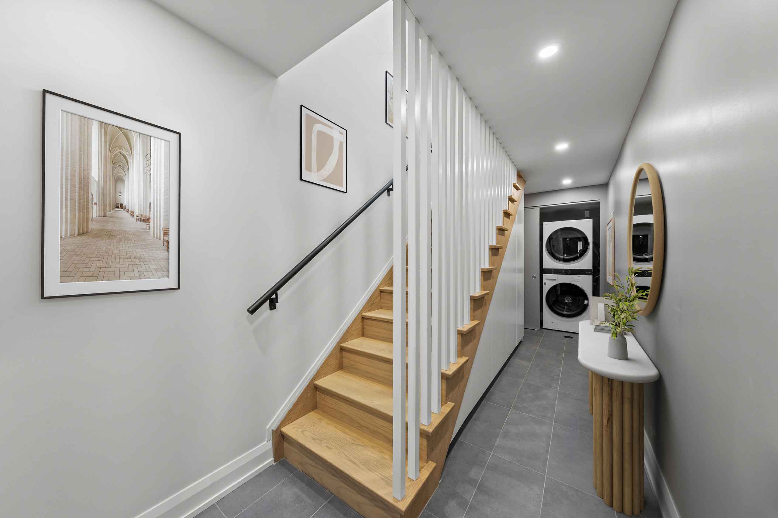Elegant hallway design with staircase, laundry area, and artistic decor